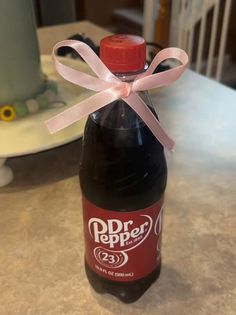 a bottle with a pink ribbon tied around it