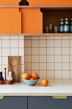 a bowl of oranges sitting on top of a kitchen counter