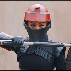 a woman wearing a helmet and holding a baseball bat