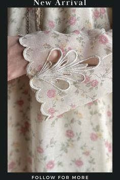 a woman's hand is holding a white flowered purse with lace on it