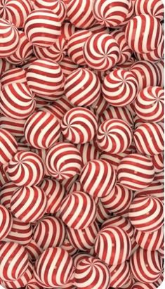 many red and white striped lollipops are stacked together