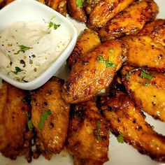 chicken wings with ranch dressing on the side and garnished with parmesan cheese