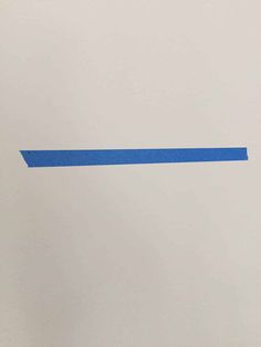 a piece of blue tape is taped to the wall