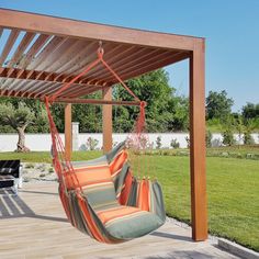 a hammock chair hanging from a pergolated patio with an attached bench