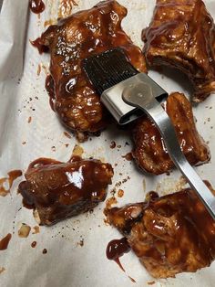 a spatula is used to scoop bbq sauce onto ribs