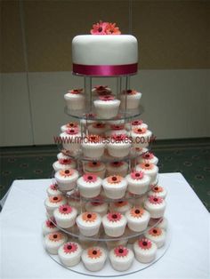 a tiered cake with cupcakes on it