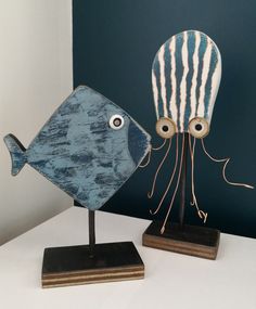 two wooden sculptures depicting an octopus and a fish