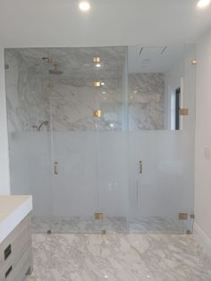 a bathroom with marble walls and flooring next to a walk - in shower stall