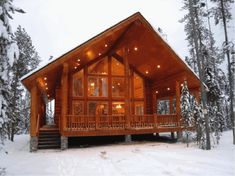 a log cabin in the snow with stairs leading up to it's second floor