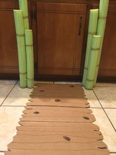 bamboo sticks are arranged on the floor in front of a counter top with an area rug made out of cardboard