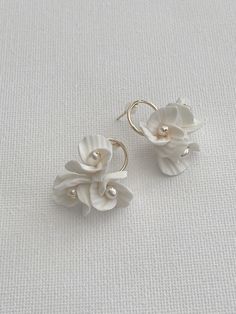 Luna floral earrings featuring Ivory clay flowers and freshwater pearls. Matching tiara to complete bridal look: Approx length of the detail is 2.5cm Clay flowers, freshwater pearls, Silver/Gold plated jewellery wire. This design can be customised (contact us for more info). As each of our pieces is handmade especially for you, we are unable to accept returns/exchanges (please contact us for more info). Pearl Flower Charm Earrings For Wedding, Pearl Drop Flower Earrings For Wedding, White Petal-shaped Earrings For Wedding, Pearl Flower Wedding Earrings, White Petal Earrings For Wedding, White Petal-shaped Wedding Earrings, White Pearl Flower Earrings With Charm, Delicate White Pearl Flower Earrings, White Pearl Earrings With Flower Charm For Wedding