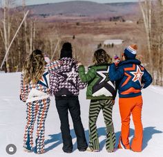 three girls are standing in the snow with their backs to each other and one girl is wearing skis