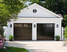 a white house with two brown garage doors