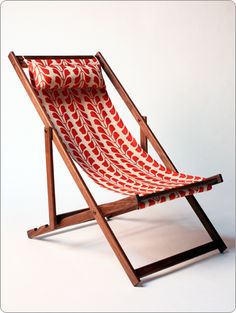 a red and white striped chair sitting on top of a wooden frame