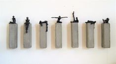 five concrete sculptures are hanging on the wall