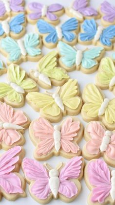 decorated cookies with pastel colors and butterflies on white tablecloth, ready to be eaten