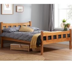 a wooden bed frame in a room with hardwood floors and gray walls, along with a wicker basket on the floor