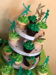 there are cupcakes that have green frosting on top of each cake stand