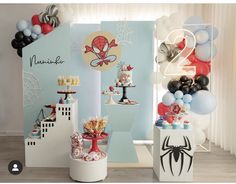 a birthday party with spiderman decorations and balloons on the wall, including cake pops