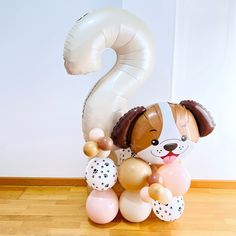 a balloon shaped like a dog with a number 2 on it's back and balloons in the air