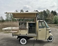 an old style food cart parked in a parking lot next to some trees and grass