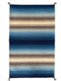 a blue and brown striped rug with fringes on the bottom, in front of a white background