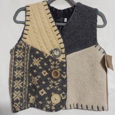 two vests are hanging on a coat hanger, one has buttons and the other is knitted