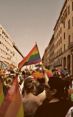 a large group of people holding flags in the street