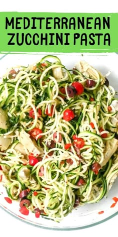 a white plate topped with zucchini pasta and veggies