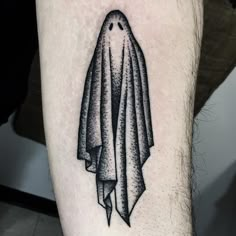 a black and white photo of a person's leg with a ghost tattoo on it