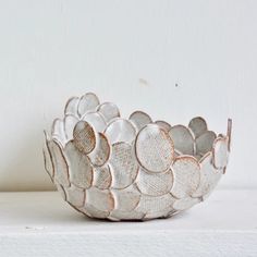 a white bowl sitting on top of a shelf