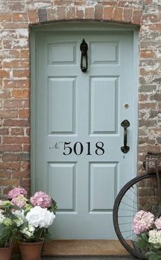 a bicycle is parked in front of a blue door with the number 5018 on it