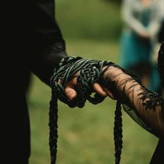 two people holding hands with black lace on them