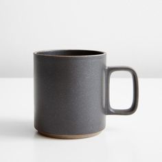 a gray coffee mug sitting on top of a white table