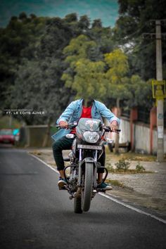 a man riding on the back of a motorcycle down a street