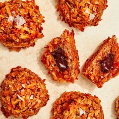 several cookies are arranged on a piece of parchment paper with chocolate and coconut flakes