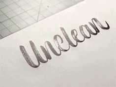 the word unclean written in cursive writing on a piece of white paper