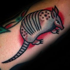 an arm with a tattoo on it that looks like a armadile, and is painted