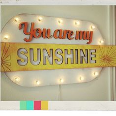 a sign that says you are my sunshine on the side of a building with lights around it