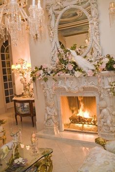 a living room with a fireplace and chandelier hanging from the ceiling above it