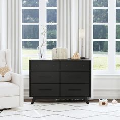 a living room scene with focus on the chest of drawers and window curtains in the background