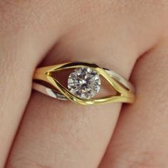 a woman's hand with a yellow and white gold ring on top of her finger