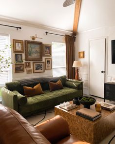 a living room with couches, tables and pictures on the wall in it's corner