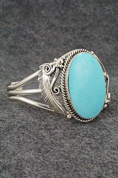 This stunning turquoise and sterling silver bracelet was made by Navajo silversmith Glen Smith. The back is partially signed RB and .925.Size: 5 1/2" (will fit up to a 6 1/2" wrist)Gap: 1"Width: 1 5/8"Cuff Width: 3/8"Free shipping on all orders! We ship with USPS and always include tracking. All orders ship within a day of payment.Returns are accepted up to 30 days after you receive your order. Just send us a message. Our shop offers cash back or store credit. The item must be returned in new co Elegant Sterling Silver Bracelet With Turquoise, Elegant Engraved Turquoise Sterling Silver Bracelet, Elegant Turquoise Engraved Sterling Silver Bracelet, Bohemian Sterling Silver Oval Cuff Bracelet, Western Style Sterling Silver Bangle, Bohemian Oval Sterling Silver Cuff Bracelet, Oval Southwestern Sterling Silver Cuff Bracelet, Southwestern Oval Sterling Silver Cuff Bracelet, Southwestern Style Oval Sterling Silver Cuff Bracelet