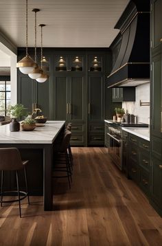 a kitchen with dark green cabinets and white counter tops, wooden flooring and pendant lights