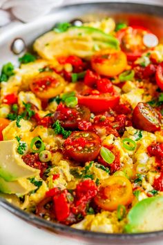 an omelet with tomatoes and other vegetables in a pan