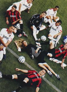 a group of young people laying on top of a soccer field next to each other