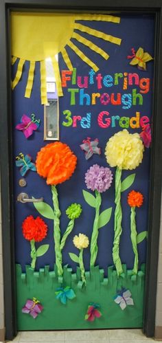 a door decorated with flowers and the words, entering through 3rd grade is an art project