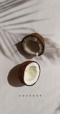 two halves of coconuts sitting on top of a white sheet with the word coconut written in it