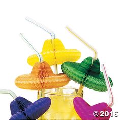 four different colored straws in a glass container with toothbrushes sticking out of them